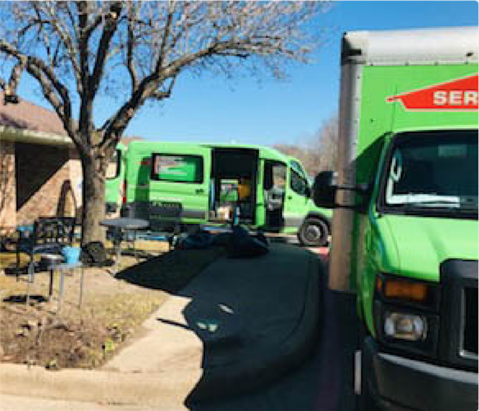 Two SERVPRO vans in driveway.