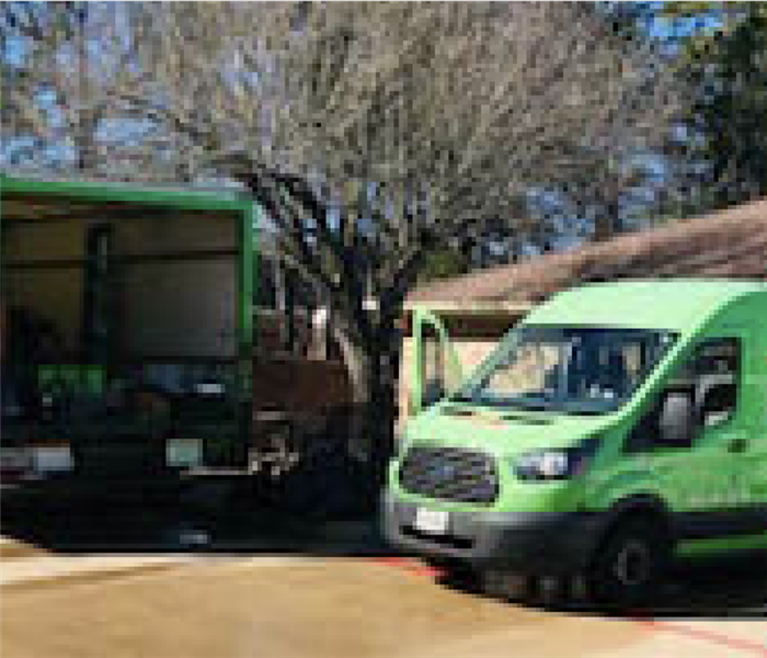 Two green SERVPRO vehicles.