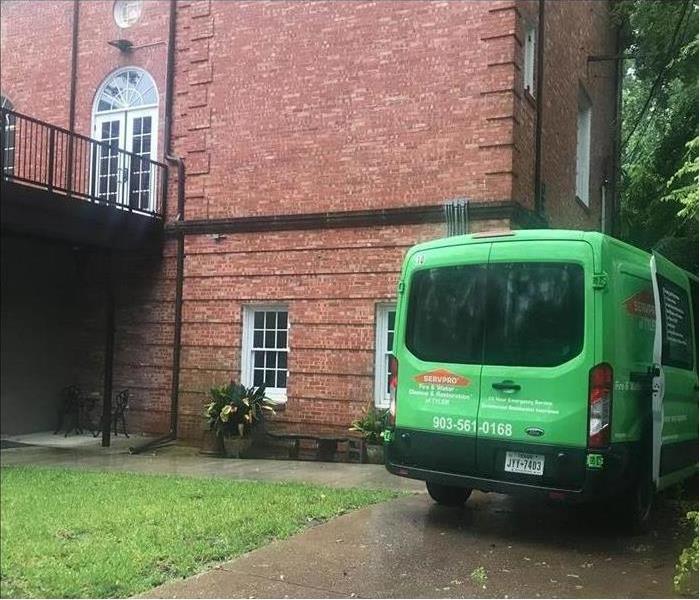 Green van parked outside a building